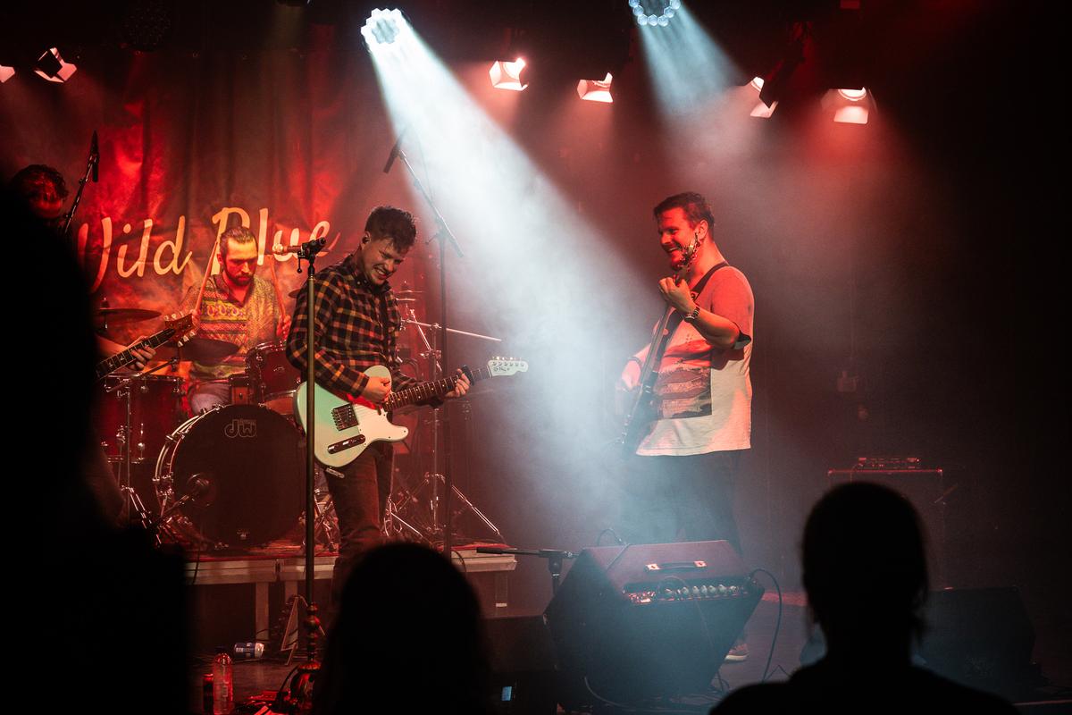 Full band on stage in red and white light